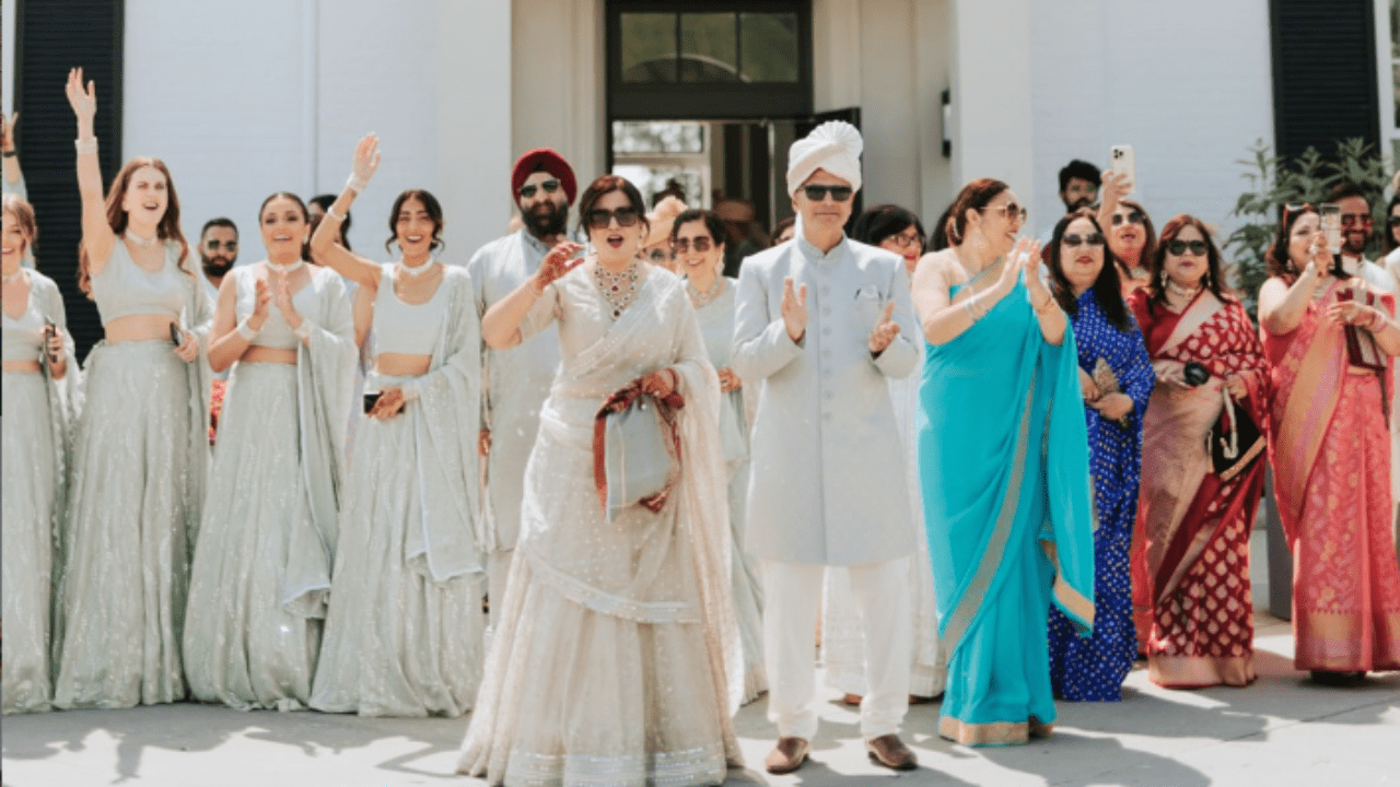 Family and guests celebrating outdoors at an Indian wedding baraat procession