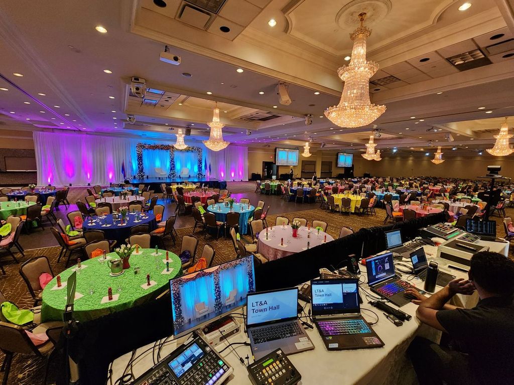 Corporate event production setup with AV control station and ballroom seating